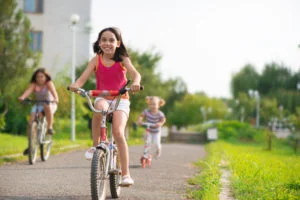 Three happy children riding on bicycle